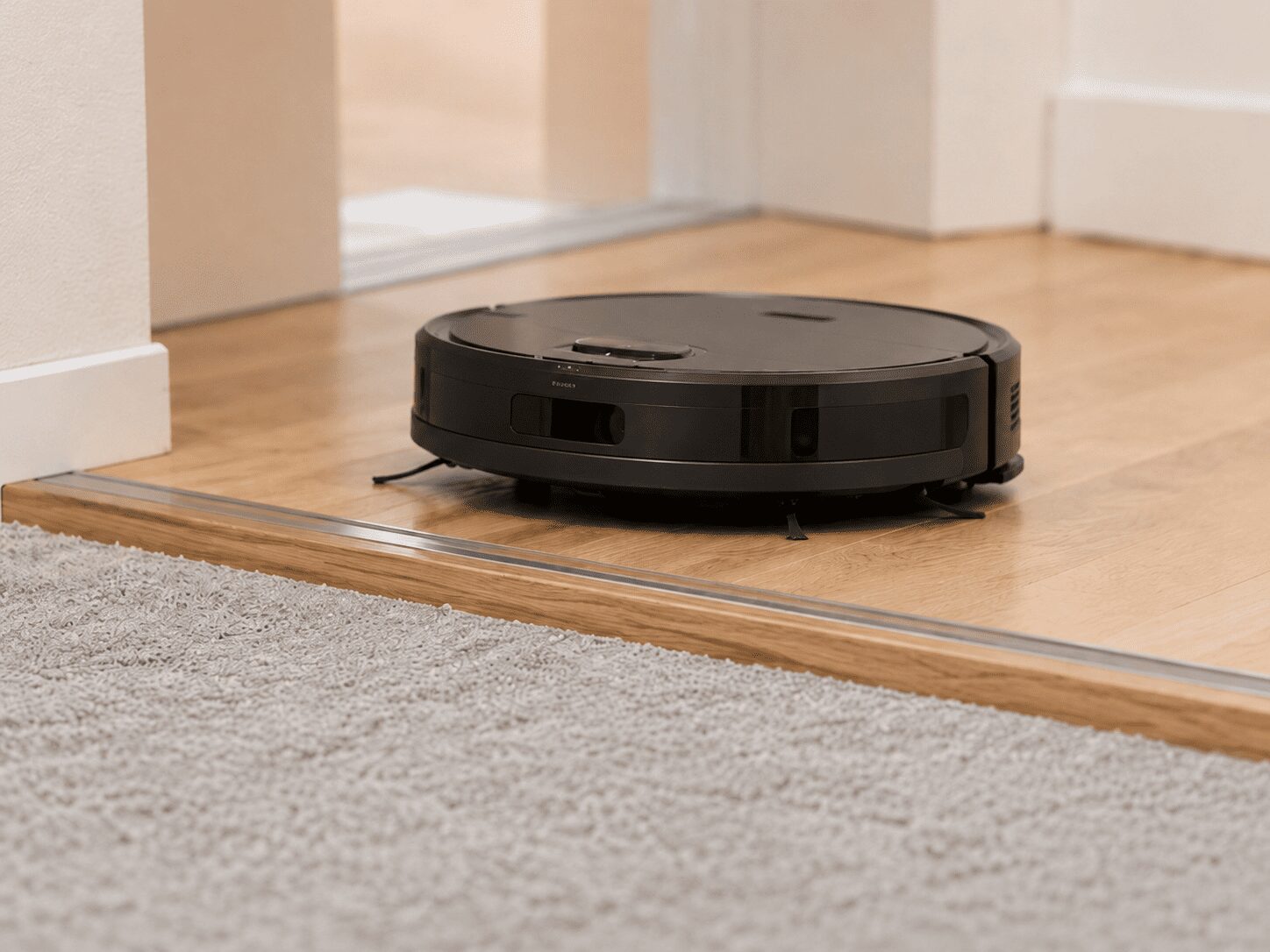 ロボット掃除機が部屋の敷居とラグ付近を走行し、段差を確認している様子